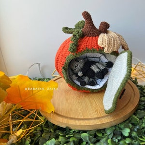 Handmade amigurumi spider sitting on a crochet pumpkin house. Unique Halloween DIY decor or gift idea made with sustainable materials.