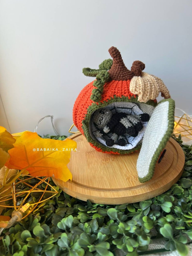Handmade amigurumi spider sitting on a crochet pumpkin house. Unique Halloween DIY decor or gift idea made with sustainable materials.