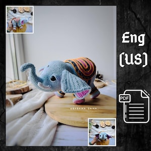 May include: A crocheted elephant toy in shades of blue, with a patterned back in orange, pink, and brown. The elephant has large ears with pink accents and is standing on a wooden surface. The text "@BABAIKA_ZAIKA" is visible.