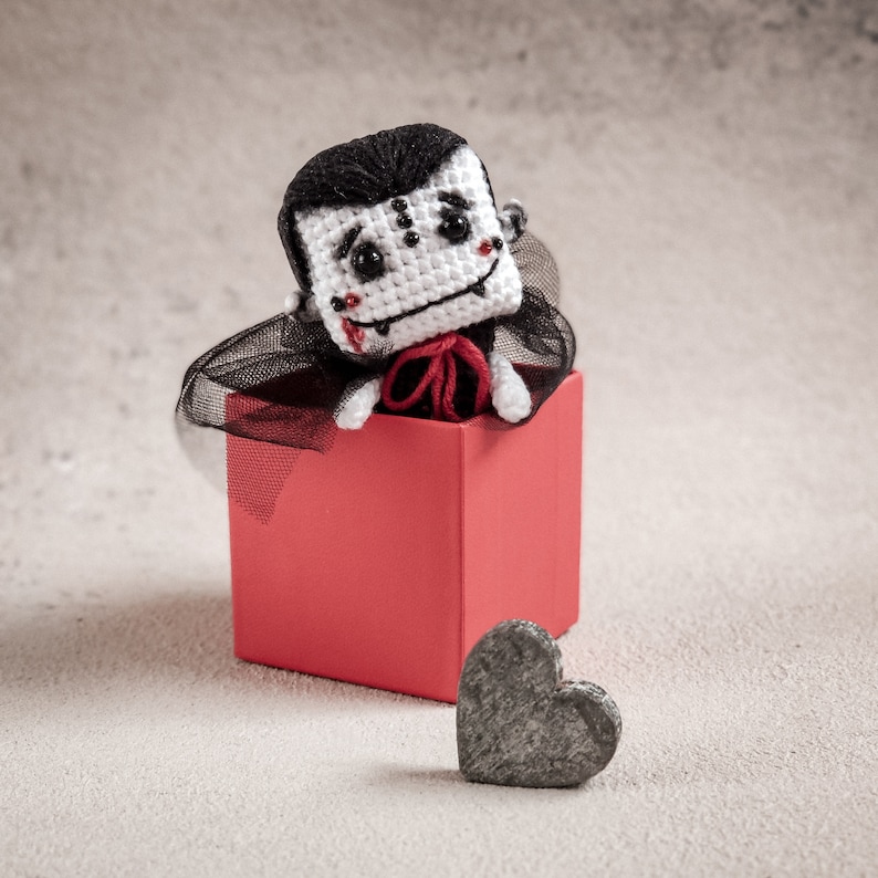 Mini amigurumi vampire sitting in a cup – an example of the finished toy from our crochet pattern. Perfect for Halloween decorations or as a fun handmade gift. A simple, love-filled DIY project