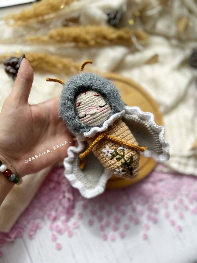 Close-up of the crochet process creating an adorable amigurumi butterfly baby doll. The pattern is designed for easy DIY crafting, making it a heartfelt gift idea and a creative project that adds joy and warmth to your handmade collection.