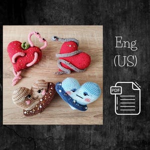 Puede incluir: Cuatro juguetes amigurumi de ganchillo en forma de corazón. Uno es rojo con una serpiente gris envuelta alrededor, otro es marrón con un diseño de chocolate, otro es azul con un diseño de galaxia y el último es rojo con un diseño de corazón rosa.