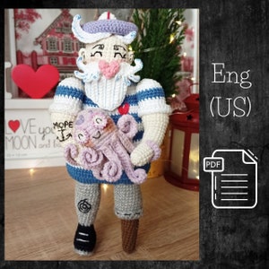 May include: Crochet pattern for a sailor amigurumi doll holding an octopus. The doll is wearing a blue and white striped shirt, a red heart, and a blue and white sailor hat. The pattern is available in English (US) and is in PDF format.