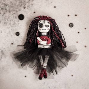 A black-and-red themed amigurumi doll with a ghostly aesthetic, holding a red heart. A perfect Halloween crochet gift.