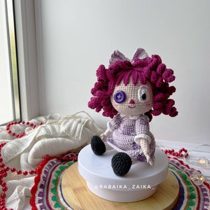 Back view of the doll, displaying the detailed crochet work on the dress and hair.