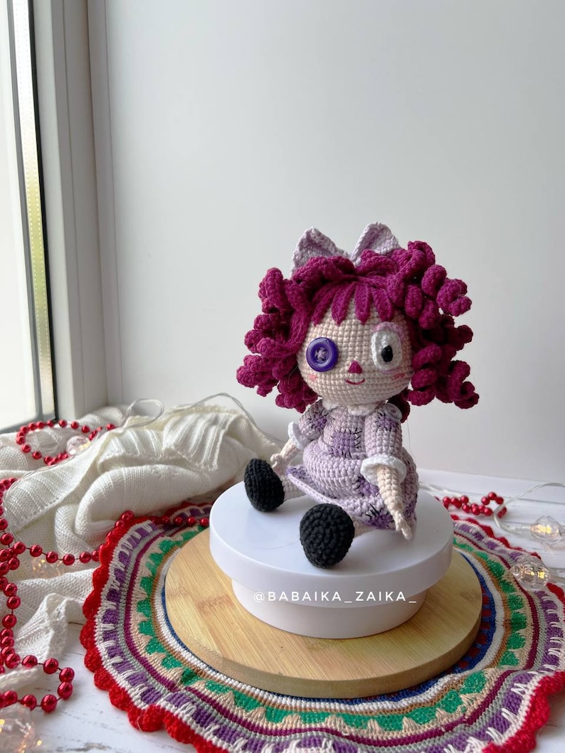 Back view of the doll, displaying the detailed crochet work on the dress and hair.