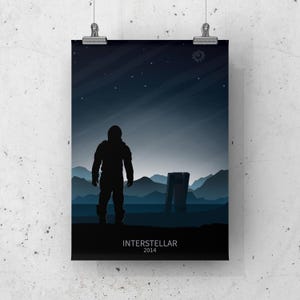 May include: A black and white minimalist poster featuring a silhouette of an astronaut standing in a landscape with a large structure in the background. The text "Interstellar 2014" is at the bottom of the poster.