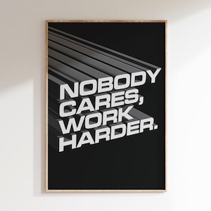 May include: Black and white motivational poster with the text "Nobody cares, work harder." The text is in a bold, 3D-style font and is set against a black background with gray diagonal lines.
