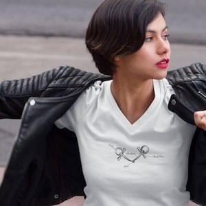 May include: A white v-neck t-shirt with a black and white illustration of a horse bit with the text "Bit", "Mouthpiece", "Jaw", and "Check Piece".