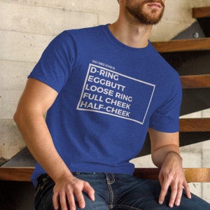 May include: A royal blue t-shirt with white text that reads "SPICY HORSE DESIGN CO. D-RING EGGBUTT LOOSE RING FULL CHEEK HALF-CHEEK"