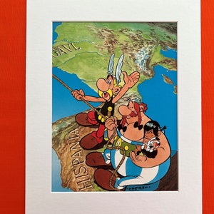 May include: A vintage cartoon illustration of three characters from the Asterix comic series. The characters are climbing a rope, with a map of Europe in the background. The text "HISPANIA" and "GAVL" are visible on the map.