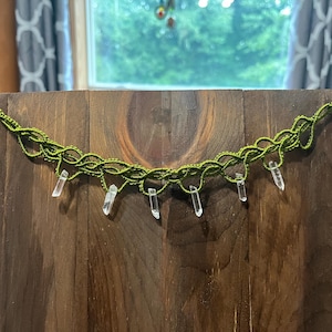 May include: A green macrame choker necklace with clear quartz crystal accents.