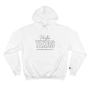 Pode incluir: Moletom branco da marca Champion com estampa gráfica preta que diz "Houston TEXAS" e "Everything's bigger in Texas".