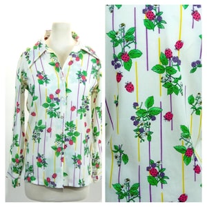 Puede incluir: Una camisa blanca de manga larga con botones y un estampado floral colorido con fresas rosas y rojas, hojas verdes, bayas moradas y rayas amarillas y moradas.