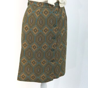 May include: A brown and blue geometric patterned skirt with a button closure. The skirt is knee-length and has a straight silhouette.