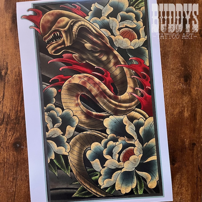 May include: A framed tattoo art print featuring a detailed illustration of an alien-like creature intertwined with stylized blue and white flowers and red accents. The print includes the text "BUDDY'S - TATTOO ART-" in the upper right corner.
