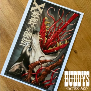 May include: A tattoo art print featuring a wolf with its mouth open, revealing a red, tentacled creature. The artwork is in a black frame with Japanese text and the text "BUDDYS -TATTOO ART-" in the bottom right corner.