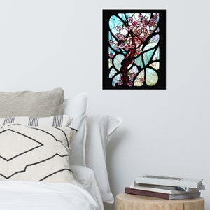 Puede incluir: Una ventana de vitrales que representa un &aacute;rbol en flor con flores rosadas sobre un fondo de cielo azul y blanco. El &aacute;rbol est&aacute; rodeado por un marco negro.