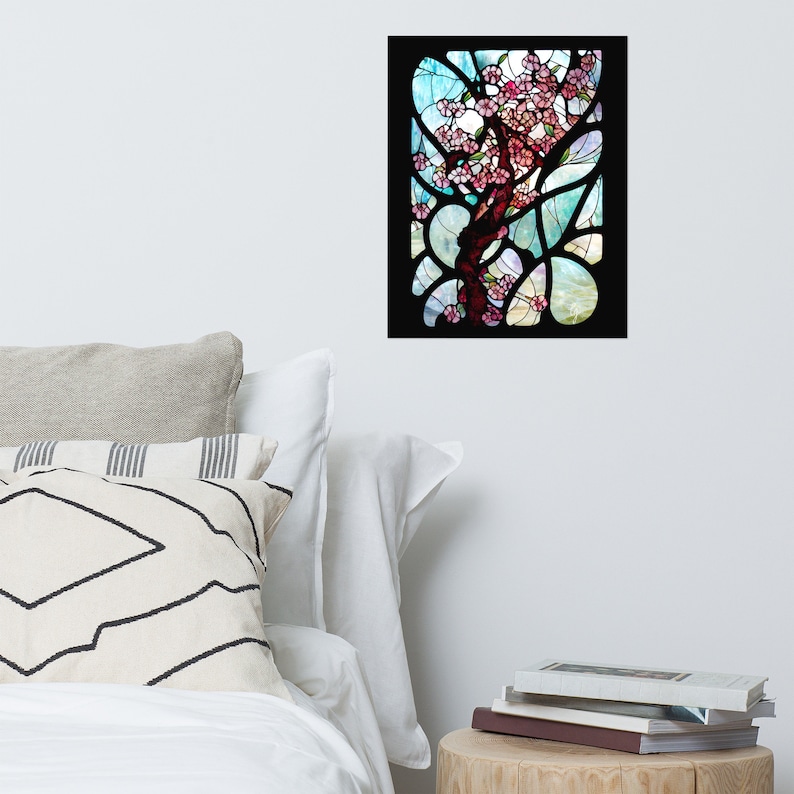 Puede incluir: Una ventana de vitrales que representa un &aacute;rbol en flor con flores rosadas sobre un fondo de cielo azul y blanco. El &aacute;rbol est&aacute; rodeado por un marco negro.
