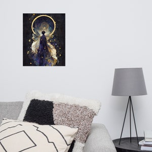 May include: An art print featuring a celestial figure with a dark blue cloak and golden accents, set against a dark, starry background. The artwork includes a golden halo and delicate details, creating a mystical and ethereal aesthetic. The print is displayed on a wall.