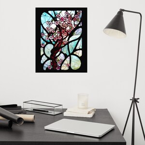 Puede incluir: Una ventana de vitrales que representa un &aacute;rbol estilizado con flores rosas sobre un fondo azul y verde.