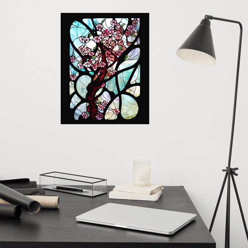 Puede incluir: Una ventana de vitrales que representa un &aacute;rbol estilizado con flores rosas sobre un fondo azul y verde.