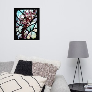 Puede incluir: Una ventana de vitrales que representa un &aacute;rbol estilizado con flores rosas sobre un fondo azul y verde.