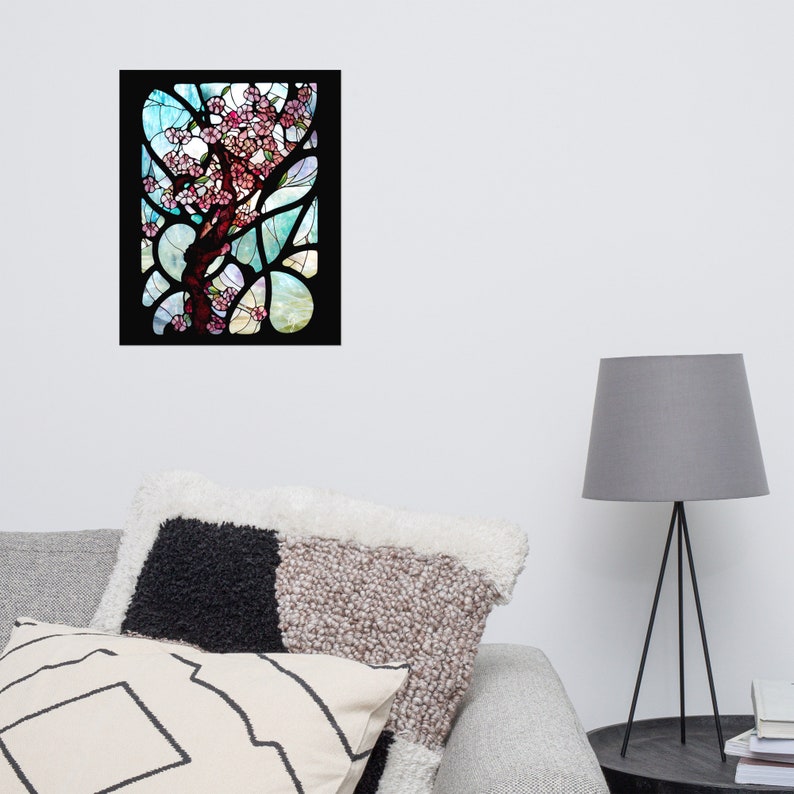 Puede incluir: Una ventana de vitrales que representa un &aacute;rbol estilizado con flores rosas sobre un fondo azul y verde.