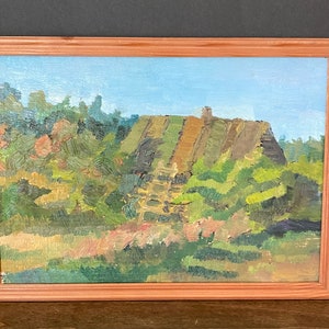 May include: A framed oil painting depicting a landscape with a green hill and trees in the foreground. The sky is a light blue with some clouds.