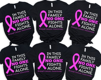 May include: Six black t-shirts with a pink ribbon and the text "In this family no one fights alone. Breast Cancer Awareness" printed on the front.