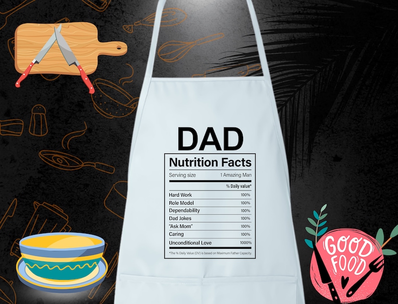 May include: White kitchen apron with a humorous nutrition facts label for "DAD". The label lists various qualities like "Hard Work", "Role Model", and "Unconditional Love", all with a 100% daily value. The apron has a red and white "Good Food" graphic in the bottom right corner.