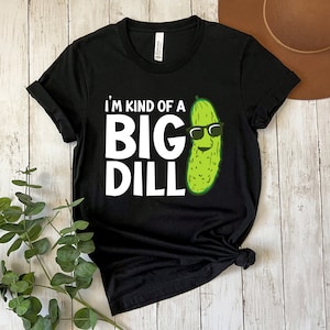Peut inclure: T-shirt noir avec du texte blanc qui dit "I'm kind of a big dill" et un cornichon vert portant des lunettes de soleil.