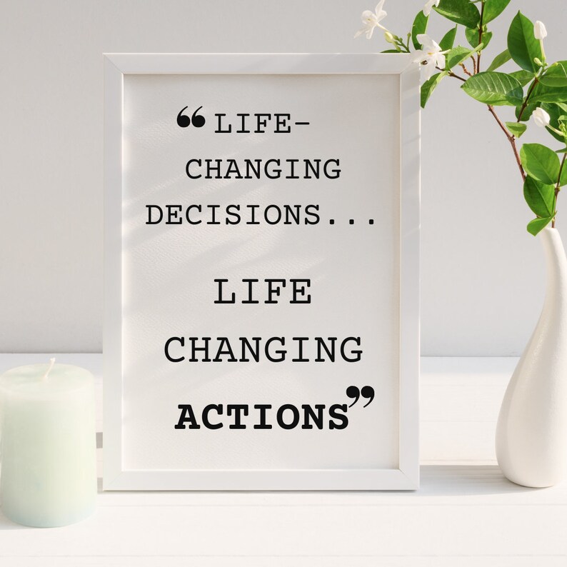 May include: White framed print with a black and white quote that reads "Life-changing decisions... Life-changing actions".