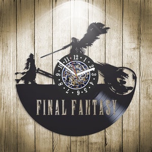 Peut inclure: Horloge en vinyle noir en forme de disque avec une silhouette d'un personnage de la série de jeux vidéo Final Fantasy. Le cadran de l'horloge est un cercle plus petit avec des chiffres romains et une aiguille d'horloge. Le texte "Final Fantasy" est imprimé sous le cadran de l'horloge.