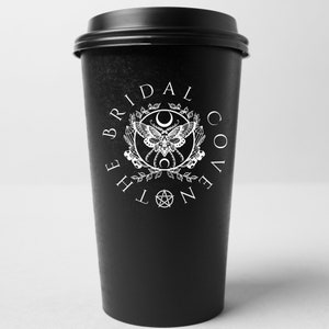 May include: Black to-go coffee cup with a white logo that says "The Bridal Coven" with a moth, crescent moon, and pentagram design.