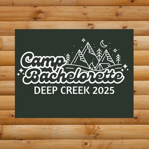 Op de afbeelding: Een donkergroen rechthoekig bord met witte tekst en afbeeldingen. De tekst luidt "Camp Bachelorette DEEP CREEK 2025". De afbeelding bevat bergen, bomen, een tent, sterren en een halve maan.