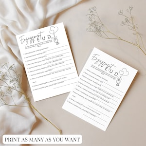 May include: Two printable cards with the text "Engagement Feud" and a list of questions for a wedding game. The cards feature a simple illustration of a ring and balloons.