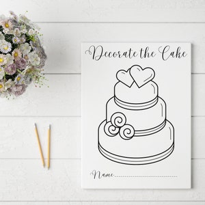 Puede incluir: Un dibujo en blanco y negro de un pastel de boda de tres pisos con dos corazones en la parte superior y un diseño de espiral en el piso inferior. El texto "Decora el pastel" está en la parte superior de la imagen. Hay una línea en blanco para un nombre en la parte inferior de la imagen.