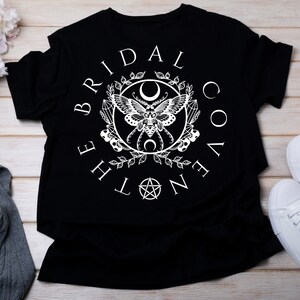 May include: Black t-shirt with a white graphic design featuring a moth, crescent moons, and the text "The Bridal Coven".