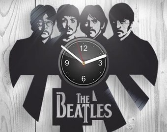 May include: Black and white vinyl record clock featuring the Beatles silhouette with the band's name "The Beatles" printed below. The clock face is black with white hands and numbers.