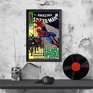 Op de afbeelding: Ingelijste vintage stripboekcover van The Amazing Spider-Man, met Spider-Man in actie. De cover bevat de tekst "ESCAPE IMPOSSIBLE!" en het Marvel Comics-logo. Een zwarte vinylplaat en een koptelefoon zijn ook zichtbaar.