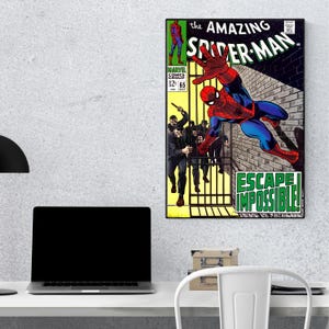 Op de afbeelding: Een ingelijste stripboekcover van The Amazing Spider-Man. De illustratie toont Spider-Man in een dynamische pose, met de tekst "ESCAPE IMPOSSIBLE!" en andere stripboekdetails. Het kleurenpalet omvat rood, blauw en geel.