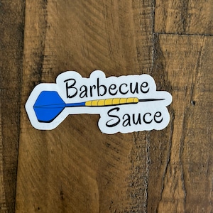 May include: A white sticker with a blue and yellow dart and the text "Barbecue Sauce".