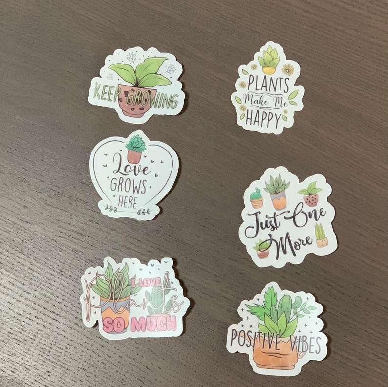 May include: Five colorful stickers with plant illustrations and text. The stickers say "Keep Growing", "Love Grows Here", "Plants Make Me Happy", "Just One More", and "Positive Vibes".