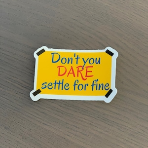 May include: Yellow sticker with black borders and the text "Don't you DARE settle for fine" in blue and red lettering.