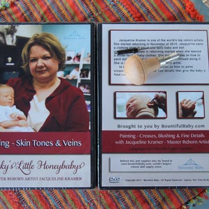Könnte beinhalten: Zwei DVDs, "Painting - Skin Tones & Veins" und "Painting - Creases, Blushing & Fine Details", zeigen Master Reborn Artist Jacqueline Kramer. Das erste DVD-Cover zeigt eine Frau, die ein Baby hält. Die zweite DVD zeigt Nahaufnahmen des Gesichts eines Babys.