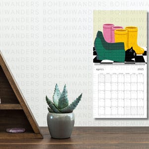 2026 Where’s the Cat? Calendar featuring adorable black cats playing hide-and-seek in everyday scenes. A cute and funny wall calendar for black cat moms and cat lovers. Includes 12 peek-a-boo cat illustrations in a modern square format. Perfect gift for cat moms, black cat owners, and anyone who loves playful feline art