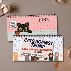 Könnte beinhalten: Zwei Spiral-Kalender. Der obere Kalender zeigt den Monat Juni mit einer schwarzen Katzenillustration. Der untere Kalender lautet "CATS AGAINST TRUMP" mit Katzenpfoten-Illustrationen und dem Text "PAWS OFF OUR DEMOCRACY MEOW".