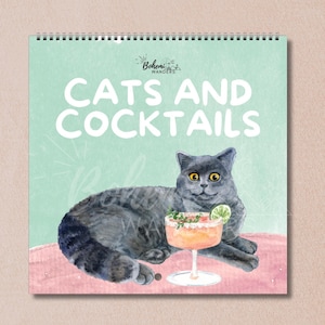 Whimsical watercolor 2026 Cats and Cocktails wall calendar featuring playful cats with pun-inspired drinks like Meowgarita, Purr-secco, and Cat-a-Tonic. A perfect gift for cat moms, cat lovers, and cocktail enthusiasts who enjoy funny cat art, pastel colors, and bar cart decor.