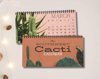 May include: A spiral-bound wall calendar titled Southwest Cacti Calendar with a terracotta-coloured cover featuring green prickly pear cacti. The open page displays the month of March with a grid of dates and a photograph of green cacti.